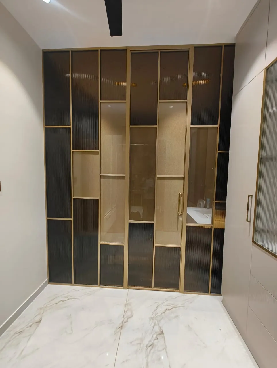 Brushed gold partition, bronze fluted glass